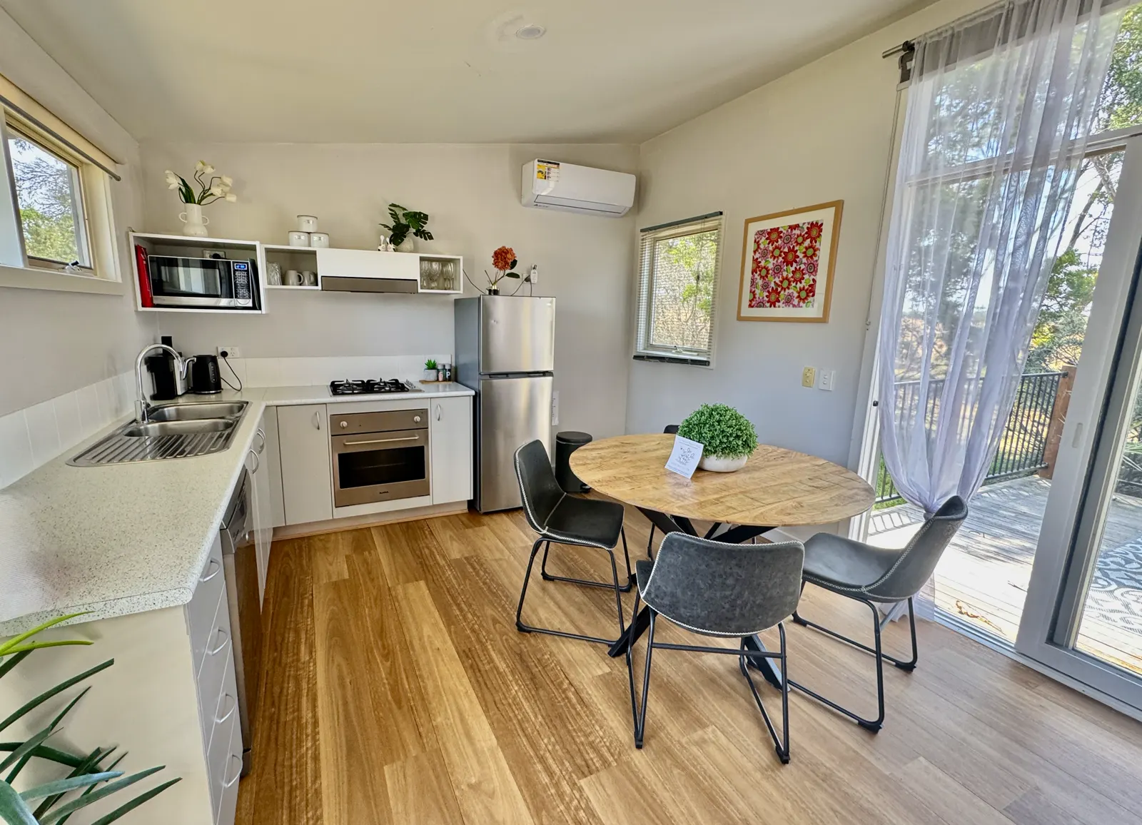 Self-contained kitchen with oven, refrigerator and round dining table — Two-bedroom Villa 107, Cowes, Phillip Island