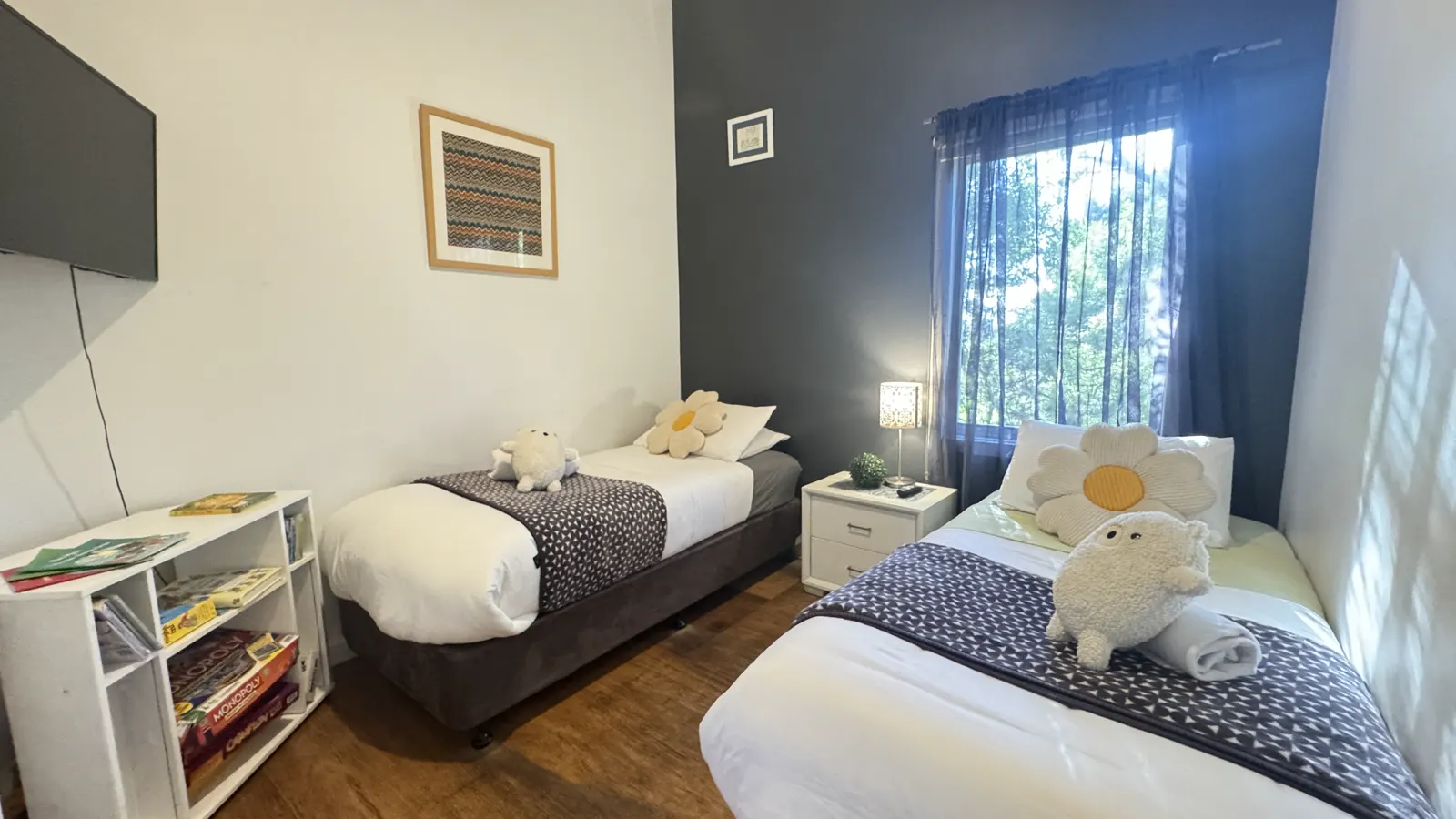 Twin bedroom with two single beds and a window overlooking greenery — Three-bedroom Villa 115, Cowes, Phillip Island