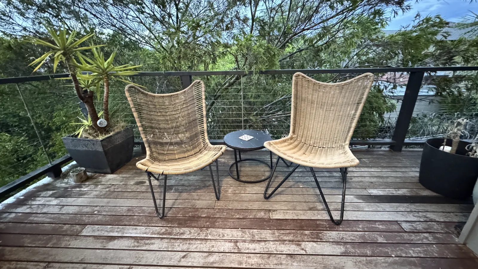 Two outdoor chairs and a small round table on the timber deck — Coastal Tones holiday home, Cowes, Phillip Island