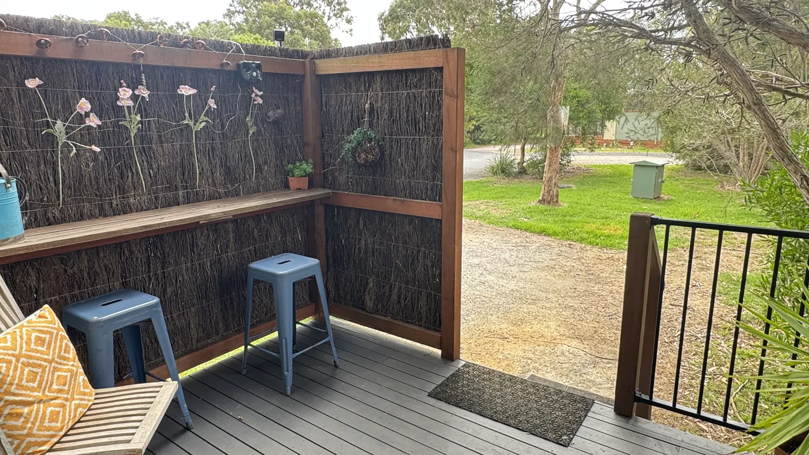 Screened outdoor deck with bar stools and a garden outlook — Studio Spa Villa 127, Cowes, Phillip Island