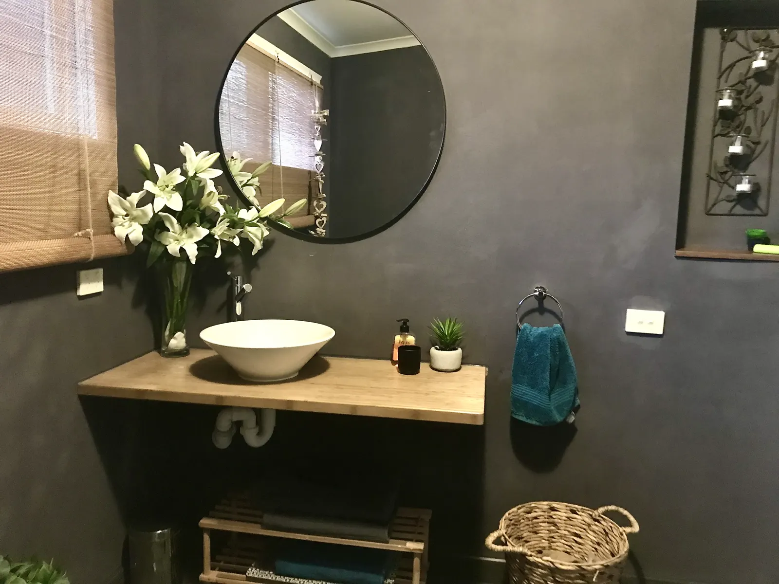 Bathroom vanity with a round mirror, vessel basin and fresh flowers — Couples Private Spa Retreat Villa 117, Cowes, Phillip Island