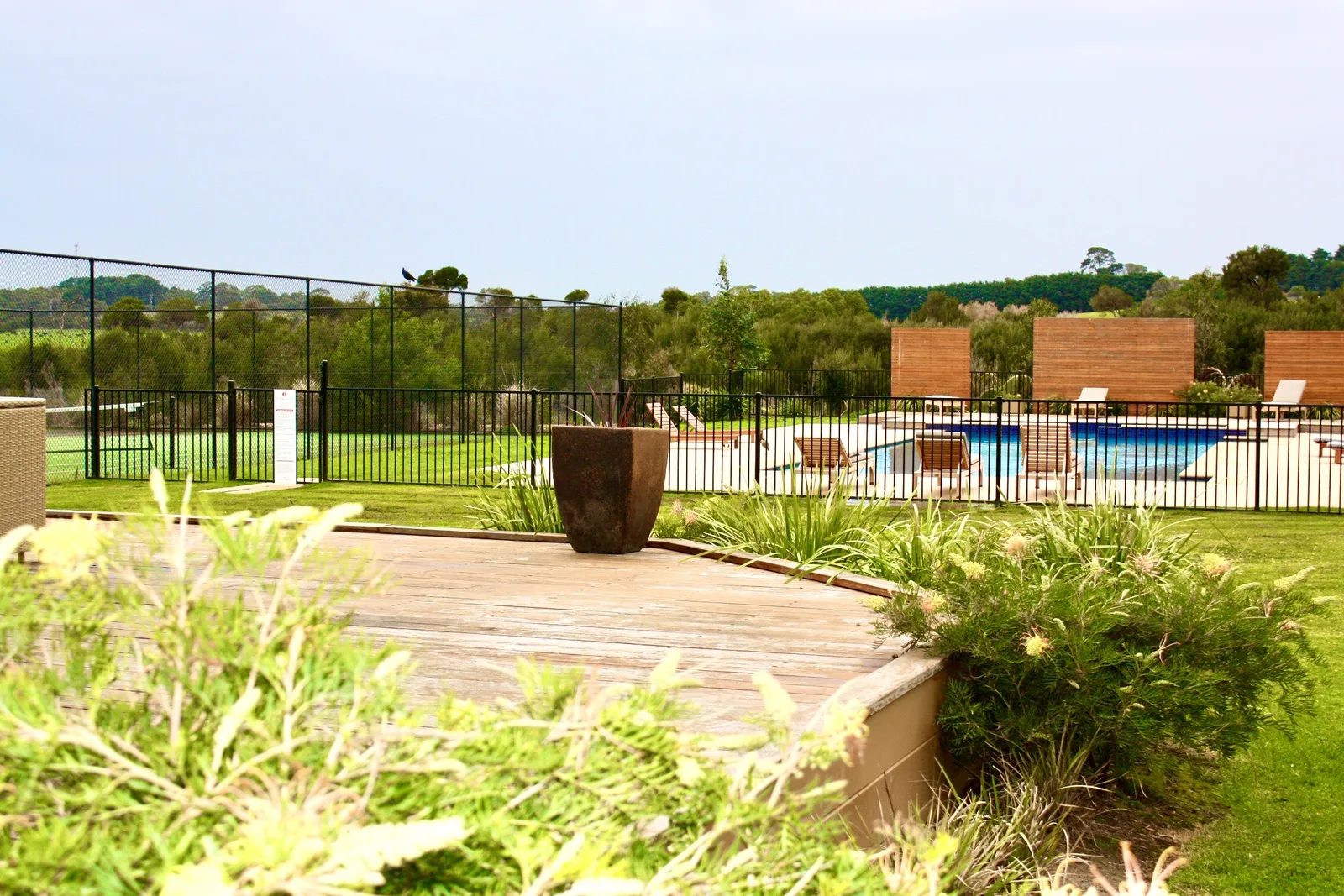 Garden deck overlooking the resort pool and tennis court